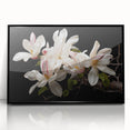 Framed wall art featuring a botanical magnolia design in vibrant colors, set against a sleek black background, perfect for modern home decor.