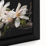 Close-up of a framed canvas wall art featuring a botanical magnolia design with delicate pink and white flowers, set against a muted background, ideal for modern home decor.