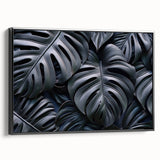 Framed botanical wall art featuring a Monstera design, showcasing vibrant green leaves against a sleek black background, ideal for modern home decor.
