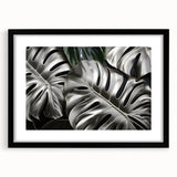 Botanical wall art featuring a Monstera leaf design framed in black with a white mat, perfect for enhancing modern home decor. Ideal for plant lovers and interior design enthusiasts.