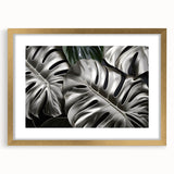 Elegant botanical wall art featuring a Monstera leaf design in a chic frame with a gold finish, enhancing any home decor with a touch of nature.