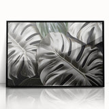 Framed acrylic wall art showcasing a vibrant Monstera plant design on a black background, perfect for modern decor. Ideal for botanical enthusiasts looking to enhance their home aesthetic.