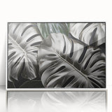 Framed botanical wall art showcasing a vibrant Monstera leaf design on a white background, perfect for adding a tropical touch to home decor.