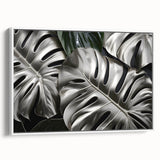 Framed canvas wall art showcasing a vibrant Monstera leaf design on a white background, perfect for botanical-themed decor. The piece adds a touch of nature-inspired elegance to any room.