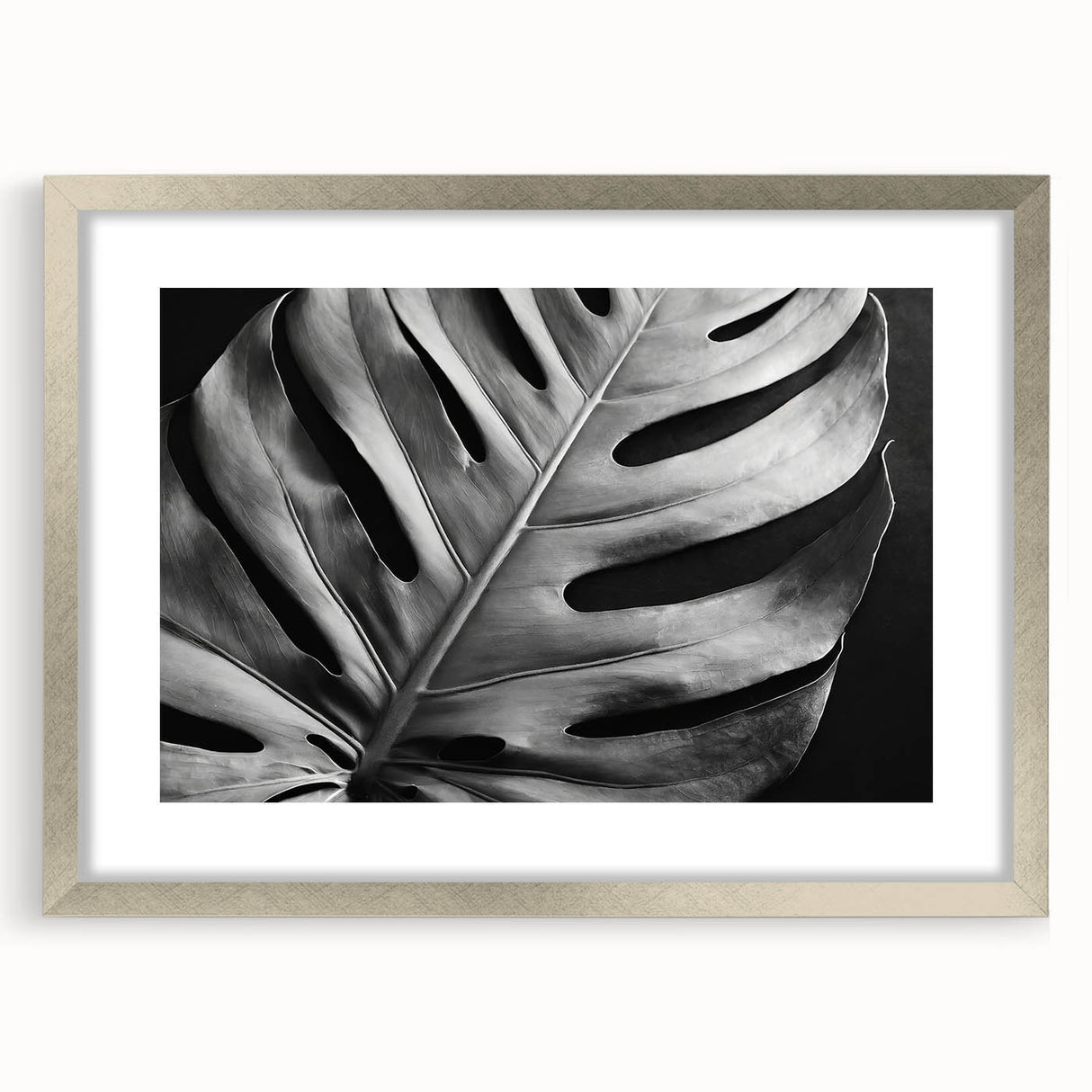 Framed botanical wall art featuring a vibrant monstera leaf design with a silver mat and frame, perfect for modern home decor and nature enthusiasts.