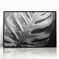 Framed wall art featuring a botanical monstera design in vibrant green and black, displayed in an acrylic frame, perfect for modern home decor.