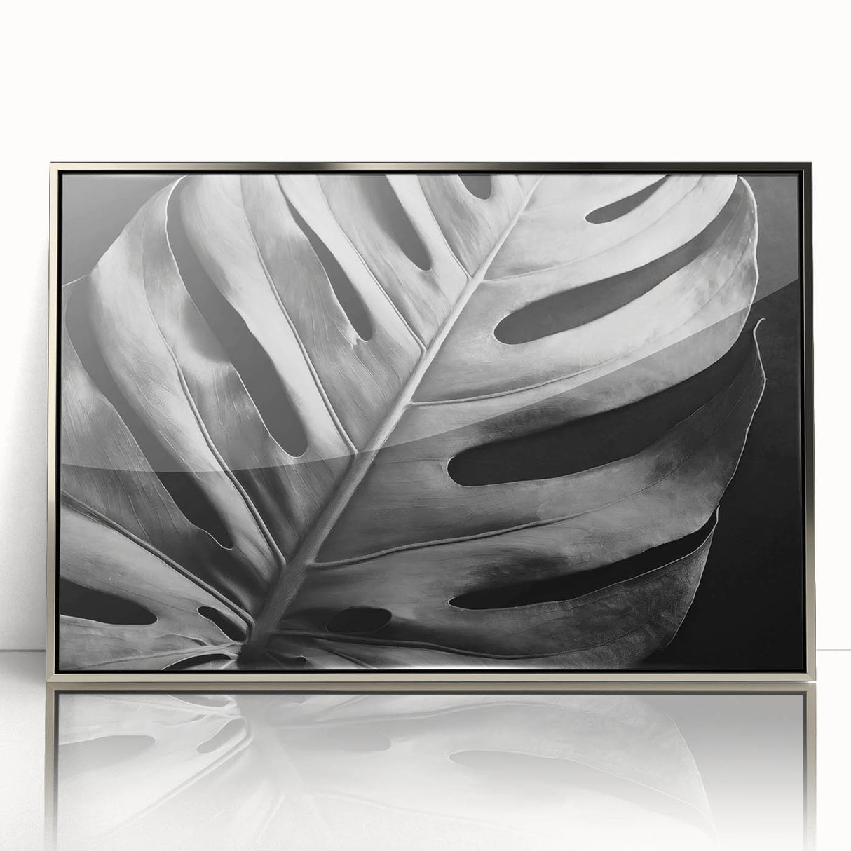 Framed wall art featuring a botanical monstera design, showcasing vibrant green leaves with a silver-acrylic frame, perfect for modern home decor.