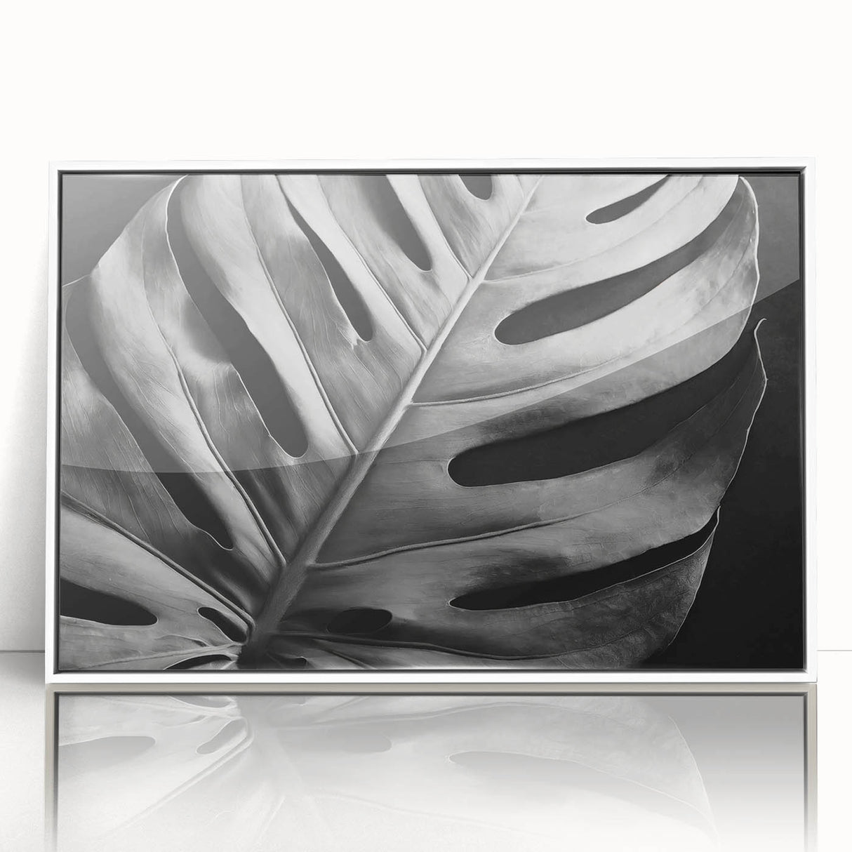 Framed botanical wall art featuring a vibrant Monstera leaf design in a sleek white frame, showcasing lush green hues and intricate details, perfect for modern decor.