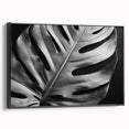 Framed wall art featuring a botanical monstera design in vibrant green hues, showcasing intricate leaf details against a black background, perfect for modern decor.