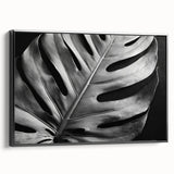 Framed wall art featuring a botanical monstera design in vibrant green hues, showcasing intricate leaf details against a black background, perfect for modern decor.
