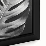 Close-up of a framed botanical wall art piece showcasing a Monstera leaf design in vibrant green hues, perfect for adding a touch of nature to home decor.