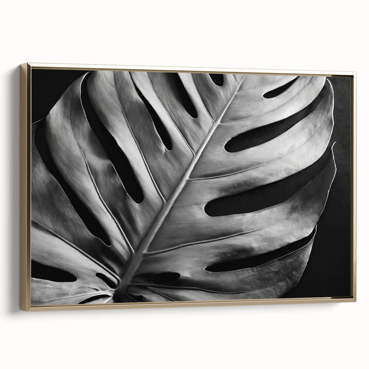 Framed botanical wall art collection showcasing a Monstera leaf design on canvas, featuring a gold frame, displayed from a side view to highlight its elegant details.