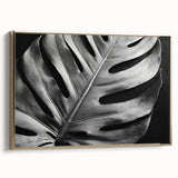 Framed botanical wall art collection showcasing a Monstera leaf design on canvas, featuring a gold frame, displayed from a side view to highlight its elegant details.
