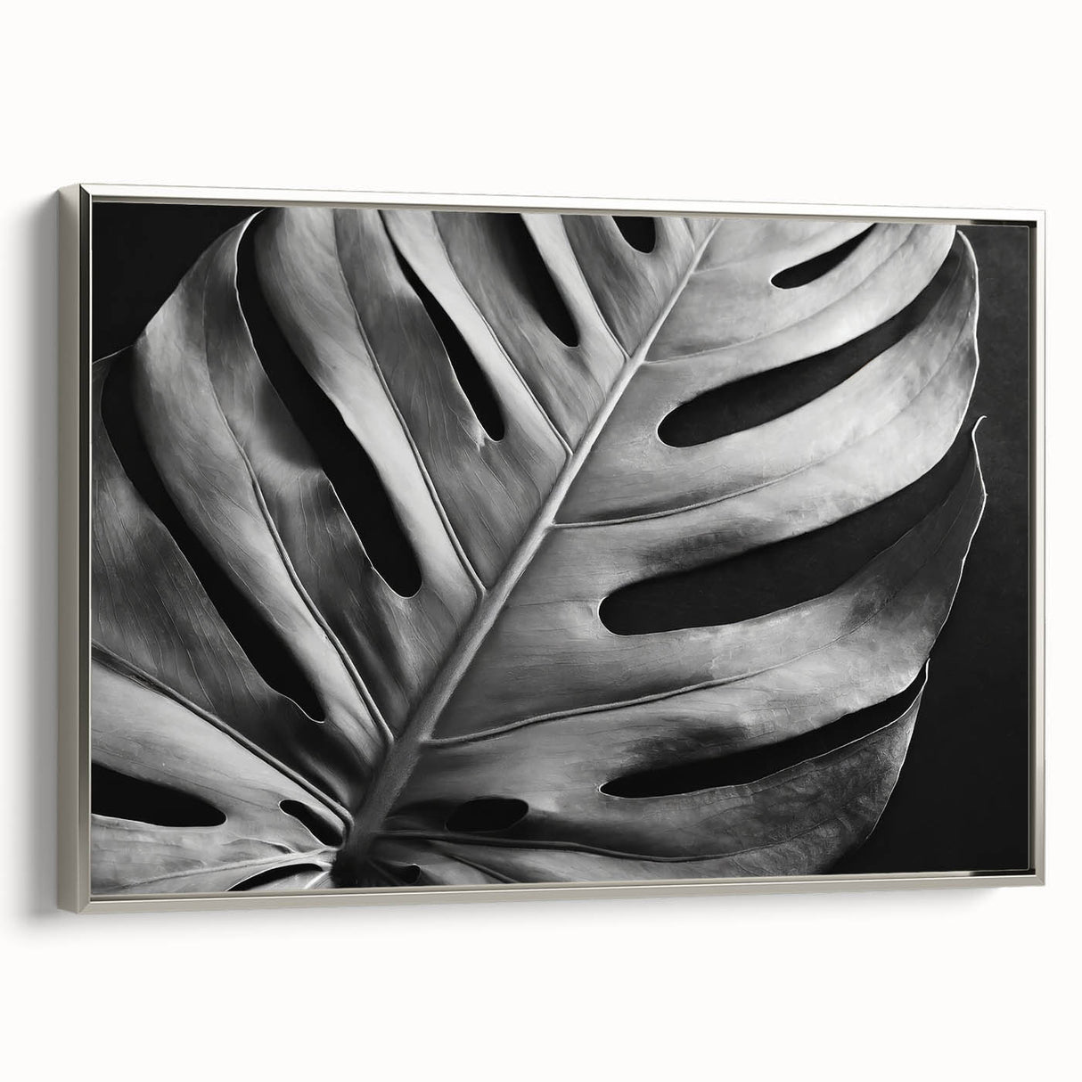 Framed canvas wall art featuring a botanical monstera design, showcasing vibrant green leaves against a silver frame, ideal for home decor enhancement.