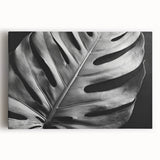 Stretched canvas wall art featuring a vibrant botanical monstera design with lush green leaves against a neutral background, ideal for enhancing modern home decor.