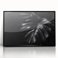 Framed wall art featuring a botanical Monstera design in vibrant greens and blacks, elegantly displayed in a sleek black frame, perfect for enhancing modern decor.