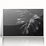 Framed wall art featuring a vibrant botanical Monstera design on a white background, showcasing lush green leaves and intricate details, perfect for home decor.