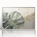 Framed botanical wall art featuring a Monstera leaf design in vibrant green tones, set against a sleek white background, ideal for modern home decor.