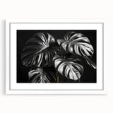 Botanical wall art collection showcasing a Monstera leaf design framed in white, highlighting vibrant green hues and intricate details, ideal for home decor.