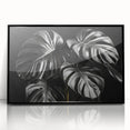 Framed wall art featuring a botanical monstera design in vibrant green tones, displayed against a sleek black frame, perfect for modern home decor and plant enthusiasts.