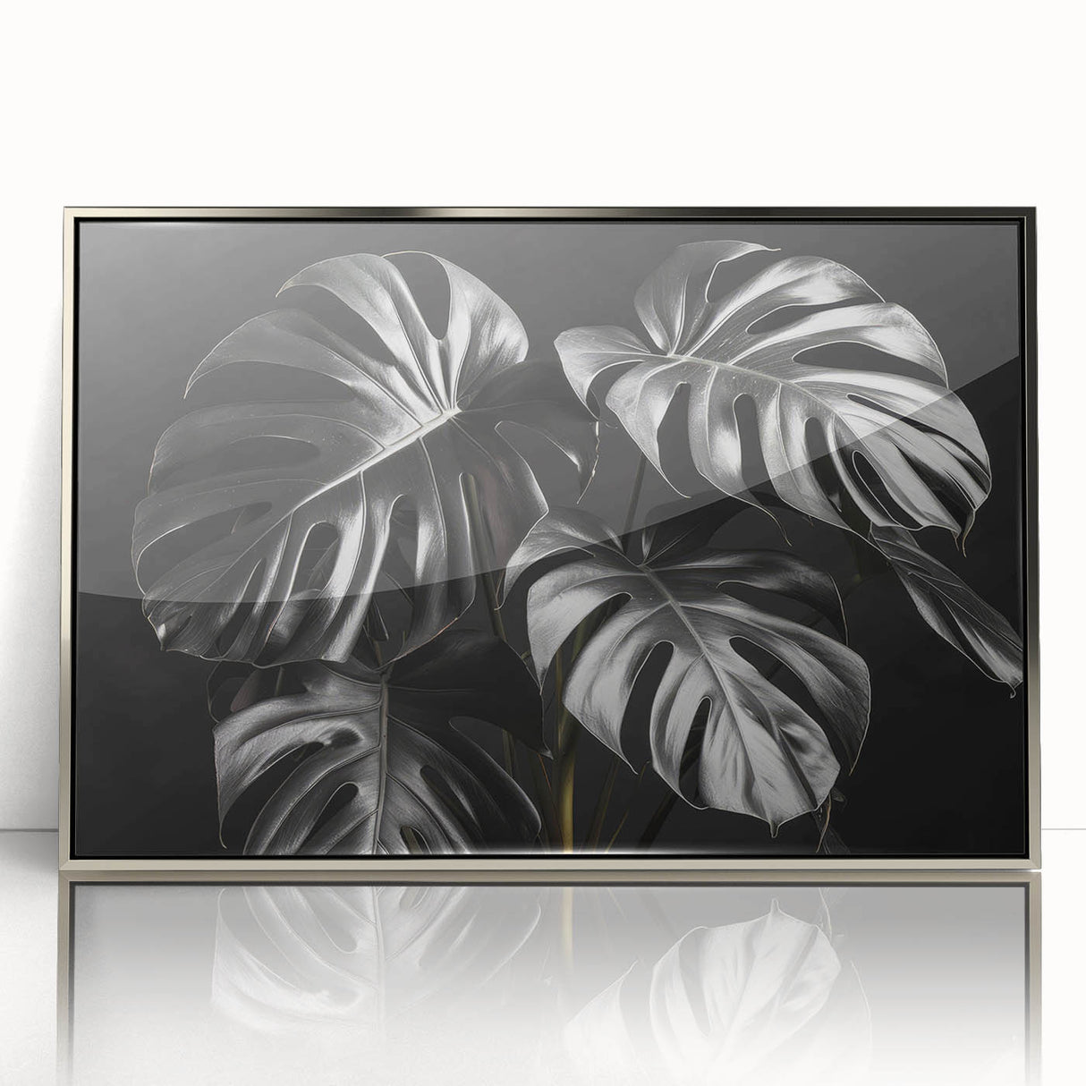 Framed botanical wall art featuring a Monstera plant design with a sleek silver frame, showcasing vibrant green leaves ideal for home decor or office aesthetics.