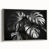 Framed wall art featuring a botanical Monstera design with vibrant green leaves against a silver background, showcasing contemporary decor for home or office.