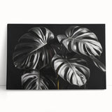 Stretched canvas wall art showcasing a vibrant botanical monstera design, featuring lush green leaves against a neutral background, ideal for home decor.