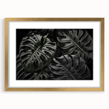 Framed botanical wall art featuring a vibrant monstera leaf design in gold accents, ideal for adding a touch of nature and elegance to home decor.