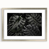 Elegant silver-framed wall art showcasing a botanical Monstera design, featuring vibrant green leaves against a neutral background, perfect for modern home decor.