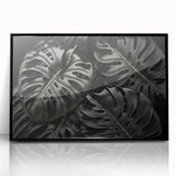 Framed botanical wall art featuring a Monstera plant design in black acrylic, showcasing vibrant green hues and intricate leaf details, perfect for home decor.
