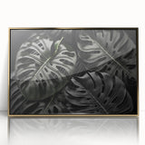 Framed botanical monstera wall art featuring vibrant green leaves encased in a sleek gold frame, perfect for adding a touch of nature to modern decor.