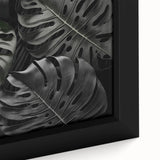 Close-up of a framed canvas wall art featuring a vibrant monstera leaf design, showcasing rich greens and botanical details, perfect for home decor enthusiasts.