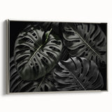 Framed wall art featuring a botanical monstera design, showcasing vibrant green leaves against a silver background, ideal for modern home decor.