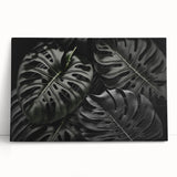 Vibrant botanical wall art featuring a monstera leaf design on stretched canvas, beautifully displayed leaning against a neutral wall, ideal for modern decor.