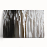 Botanical wall art featuring a vibrant design of assorted flowers and mushrooms on a stretched canvas, leaning against a white wall, ideal for home decor.
