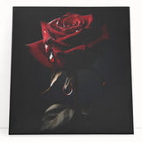 Botanical rose design wall art on stretched canvas, showcasing vibrant pink and green hues, leaning against a neutral wall, ideal for home decor enhancement.