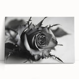 Botanical rose wall art design printed on stretched canvas, featuring vibrant pink and green hues, elegantly leaning against a neutral background, perfect for home decor.