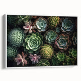 Framed canvas wall art featuring a botanical design of vibrant succulents in a modern white frame, ideal for home decor. The piece showcases lush greens and earthy tones, adding a fresh, natural touch to any interior space.