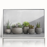Framed wall art showcasing a vibrant botanical design featuring assorted succulents in various shades of green, displayed against a sleek white background, perfect for home decor.
