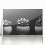 Framed wall art featuring a colorful botanical design of succulents and flowers in a white frame, perfect for enhancing modern home decor.