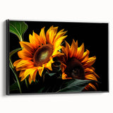 Framed canvas wall art featuring a botanical sunflower design with vibrant yellow petals and green leaves, showcased in a sleek black frame, ideal for home decor.