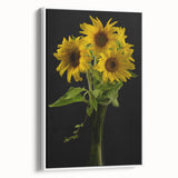 Framed wall art featuring a botanical sunflower design on canvas, showcasing vibrant yellow petals and green leaves, set against a clean white background. Ideal for brightening home decor or adding a nature-inspired touch to any room.