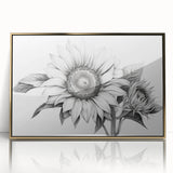 Framed wall art featuring a botanical sunflower design with vibrant yellow petals and delicate green leaves, elegantly displayed in a gold acrylic frame. Ideal for brightening up any space.