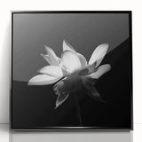 Framed wall art showcasing a vibrant tropical flower design with lush green leaves, featuring a sleek black frame, ideal for home decor in modern interiors.