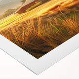 Rolled canvas artwork showcasing a serene landscape with a rustic barn, vibrant green fields, and a soft blue sky, ideal for home decor.