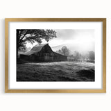 Framed wall art showcasing a serene landscape with rustic barns, featuring a gold mat and elegant frame, ideal for enhancing home decor aesthetics.