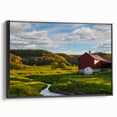 Framed canvas wall art showcasing a picturesque landscape with a rustic barn, set against a vibrant sunset; features a sleek black frame and adds charm to any decor.