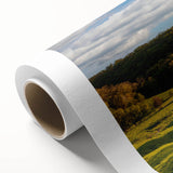 Rolled canvas wall art featuring a serene landscape with a rustic barn, vibrant green fields, and a clear blue sky, ideal for home decor enhancement.