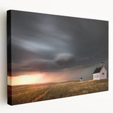 Stretched canvas wall art showcasing a serene landscape featuring a rustic red barn surrounded by lush greenery and a clear blue sky, ideal for home decor.