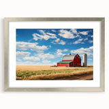 Framed wall art featuring a landscape scene with a rustic barn, presented in a silver frame with a mat, ideal for enhancing home decor and adding a touch of rural charm.